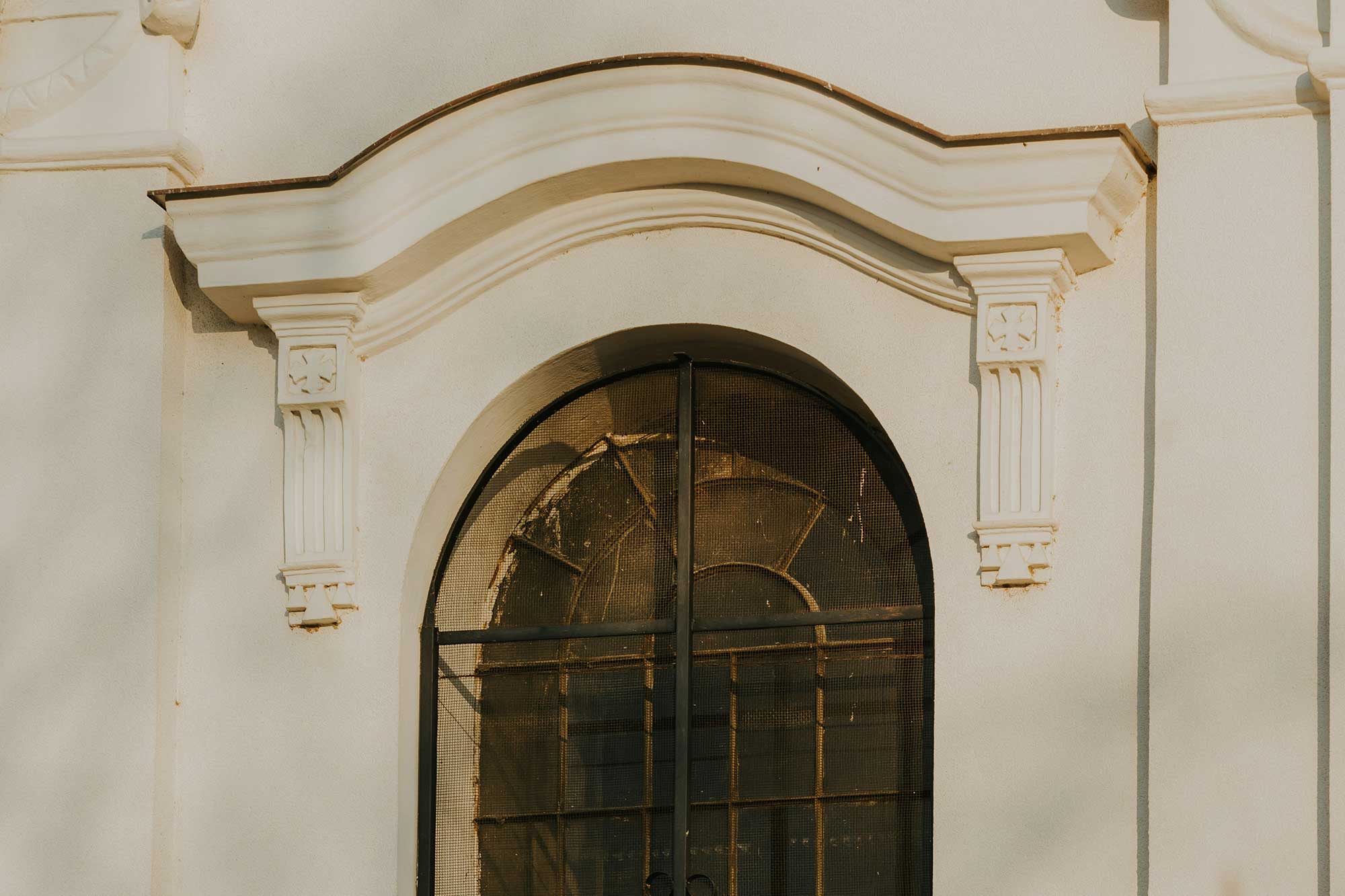 Arched glass window on a white building